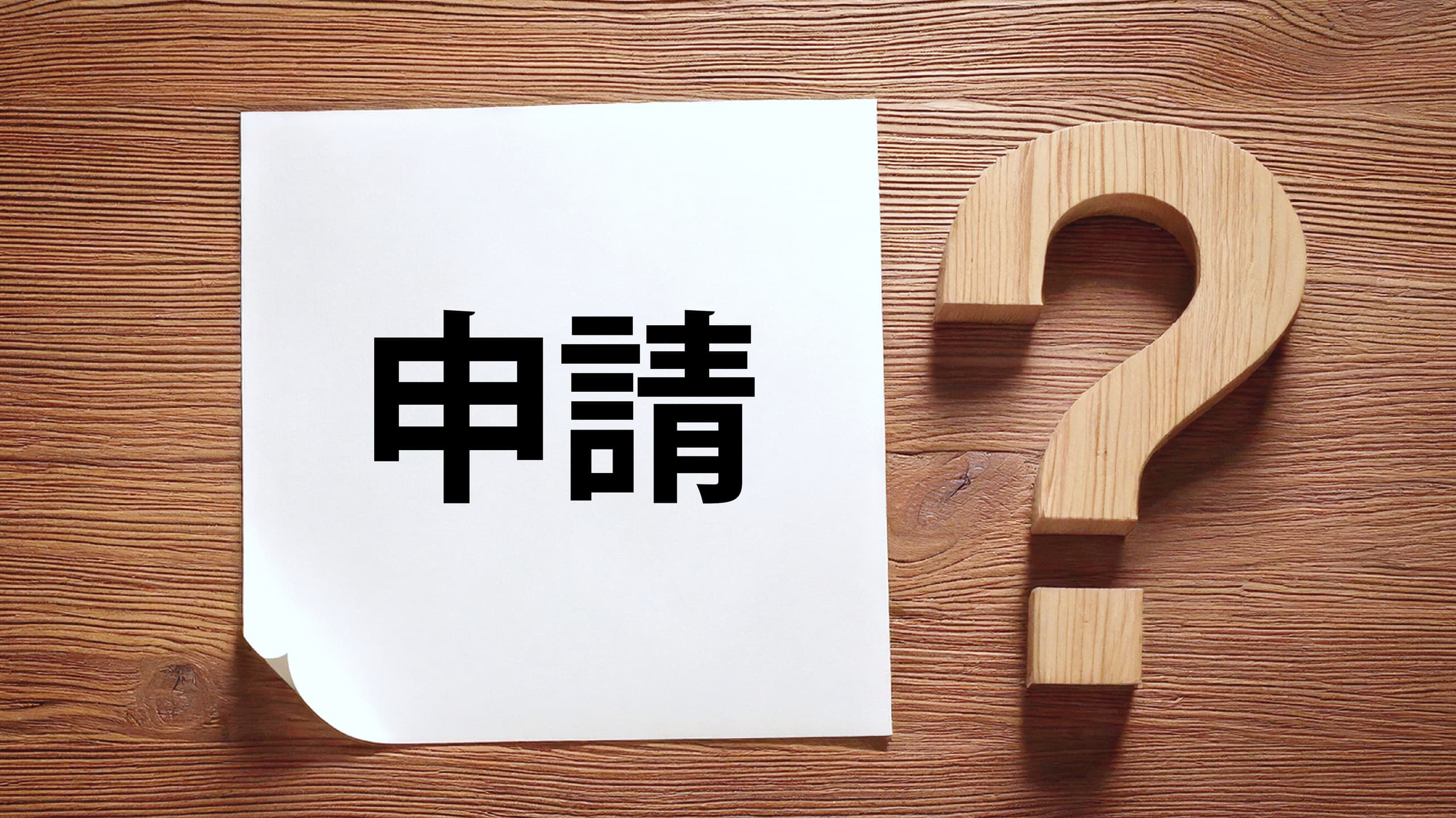申請サポート・書類作成代行を行う行政書士のサービスを表す、申請書と疑問符のイメージ写真