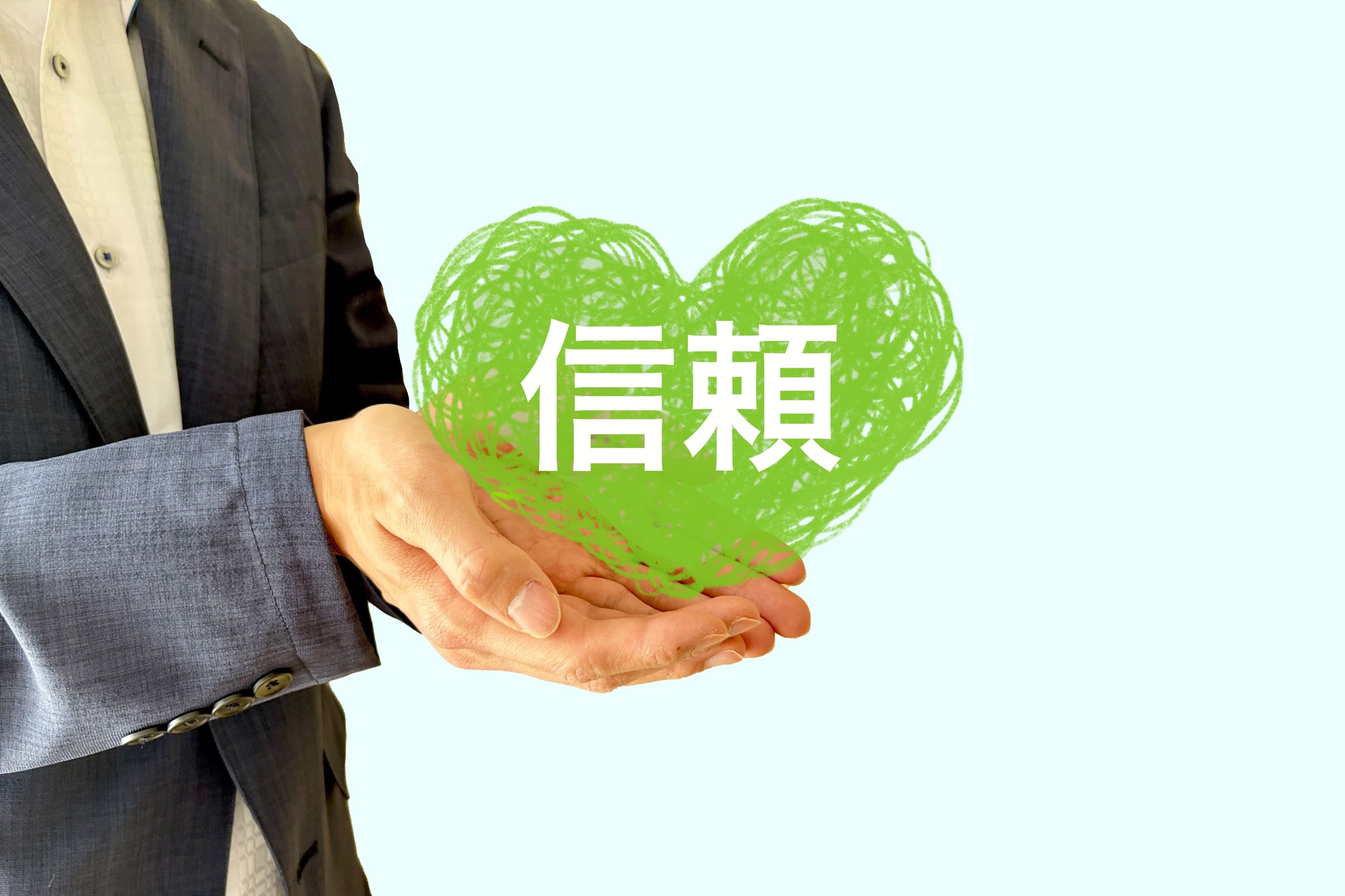 信頼・安心を提供する行政書士サービスを表す緑のハートとスーツ姿の人物の写真